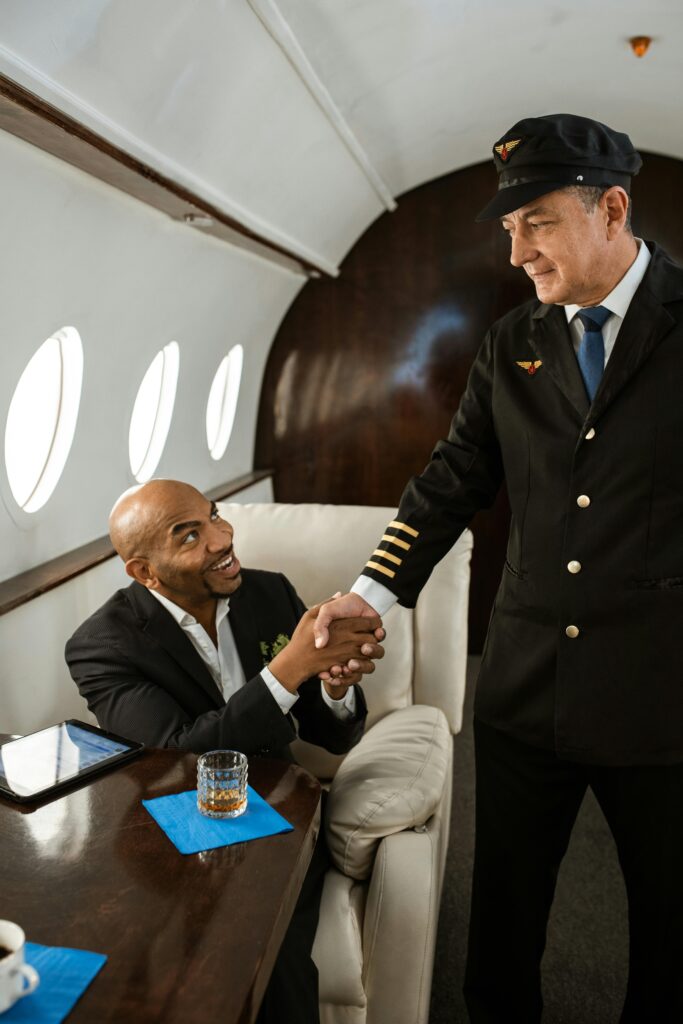 A friendly handshake between a businessman and a pilot inside a private jet.
